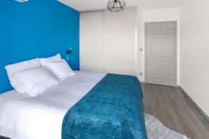 een slaapkamer met een groot bed met een blauwe muur bij O Ciucciarella - Appt climatisé pour 4 in Grosseto-Prugna
