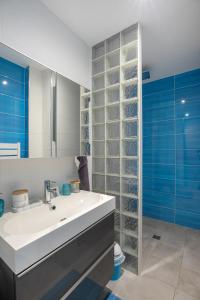 een badkamer met een wastafel en een glazen wand bij O Ciucciarella - Appt climatisé pour 4 in Grosseto-Prugna