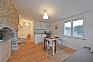 a kitchen and living room with a table and chairs at Le Mas des Rouquets - avec piscine et jardin in Anduze