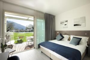 a bedroom with a bed and a sliding glass door at Seven Park Hotel Lake Como - Adults Only in Colico