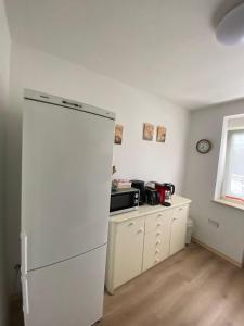 uma cozinha com um frigorífico branco e um micro-ondas em ZV-Scholtz Monteurswohnungen em Burgkirchen an der Alz