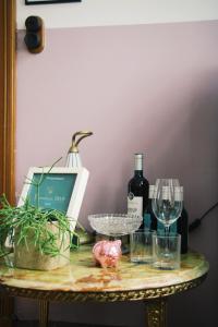 een tafel met twee glazen en een fles wijn bij B&B Herenhuis1919 in Lo-Reninge