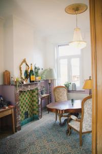 a living room with a table and a fireplace at B&B Herenhuis1919 in Lo-Reninge