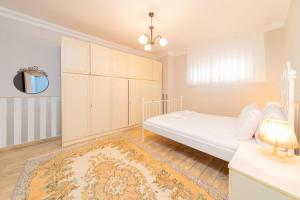 - une chambre avec un lit blanc et un tapis dans l'établissement Stylish Flat with Modern Design in Antalya, à Antalya