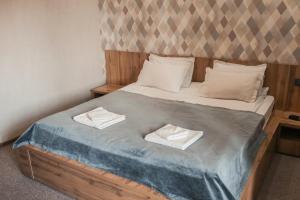 Mardin Hotel في ألماتي: غرفة نوم عليها سرير وفوط