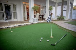 um putting green com tacos de golfe e bolas nele em Belvedere Boutiqe Hotel em Windhoek