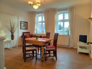 a dining room with a wooden table and chairs at Romantische Ferienwohnung Unter den Linden in Buchholz