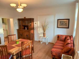 a living room with a couch and a table at Romantische Ferienwohnung Unter den Linden in Buchholz