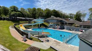 a large swimming pool with a slide in a yard at Hazel Bank A-Frame Holiday Property in Devon in Chudleigh