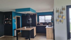 a kitchen with blue walls and a wooden table at Maison 3 chambres vue mer et phare in Plouarzel