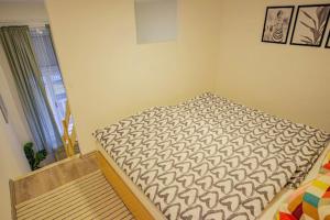 een klein bed in een kamer met een raam bij Cosy flat in Akácfa str., Aya in Boedapest