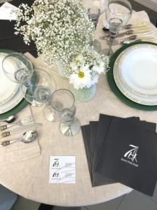 a table with plates and glasses and flowers on it at Seven Park Hotel Lake Como - Adults Only in Colico
