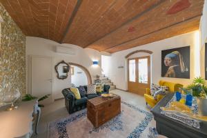a living room filled with furniture and a wooden ceiling at Villa Cristina in Riparbella