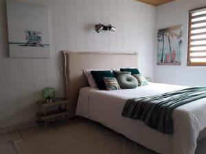 a bedroom with a large white bed with pillows at Belle de Dune in La Baule