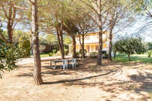 a park with a bench and trees in front of a house at Villa Gioia Relais in Avola