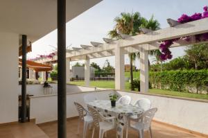 a patio with a table and chairs and a fence at Birds&Nature in L'Eucaliptus