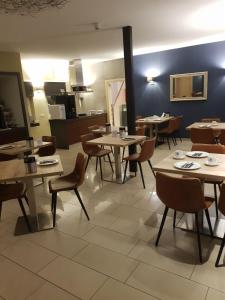 ein Esszimmer mit Tischen und Stühlen in einem Restaurant in der Unterkunft Hotel Restaurant Fritz in Gronau