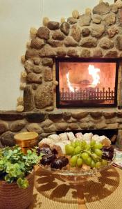 una mesa con chimenea y un plato de comida delante en Brīvdienu māja Būmaņi, en Dreiliņi