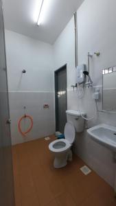 y baño con aseo y lavamanos. en Homestay Sri Pelangi Segamat, en Segamat