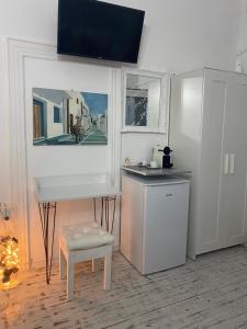 cocina con fregadero, mesa y taburete en Cozy Studio Mykonos Town, en Mykonos ciudad
