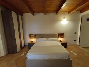 a bedroom with a large bed and two night stands at Il Rifugio in Casertavecchia