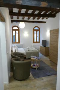 Ecco Suites Apartments في البندقية: غرفة نوم مع سرير وغرفة معيشة