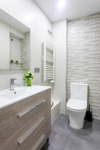 y baño con aseo, lavabo y espejo. en Precioso piso moderno: Terraza, A/C, NetFlix, WiFi en Valencia