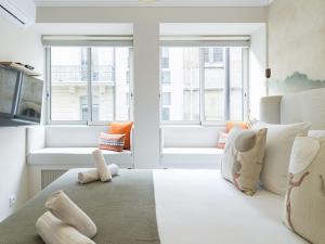 Jest to biały pokój z dużym łóżkiem i oknami. w obiekcie The Rosemary Suite Eiffel Tower w Paryżu
