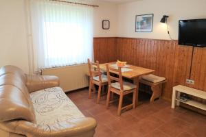 een woonkamer met een tafel en een leren bank bij Apartma Andrej in Rateče