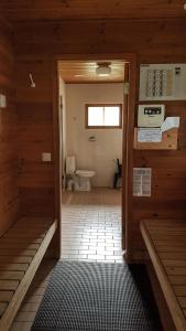 Habitación con baño con aseo y puerta. en Vilkman of UNESCO World Heritage Site Verla, en Kouvola