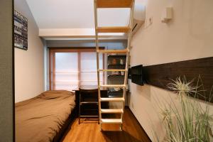 1 dormitorio con litera y escalera en Stylewood Sangenjaya, en Tokio