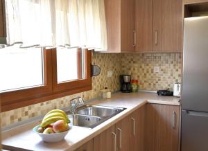 a kitchen with a sink and a bowl of fruit at Zefyros in Samothráki