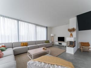 a living room with a couch and a tv at Luxury villa with boathouse on the Veerse Meer in Arnemuiden