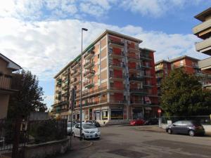 a large apartment building with cars parked in a parking lot at Afrodite Loft Hermes in Verona
