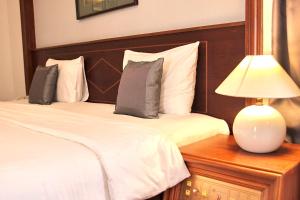 sypialnia z 2 łóżkami i lampką na stole w obiekcie Royal Hotel Saigon w Ho Chi Minh