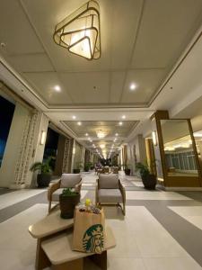 a lobby of a hotel with chairs and a table at Modern Living by The Celandine DMCI in Balintawak in Manila