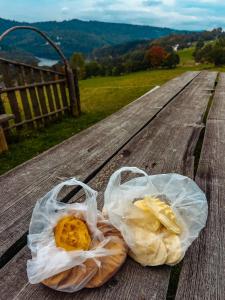 two plastic bags of food sitting on a wooden table at MALINOWA OSADA in Wisła