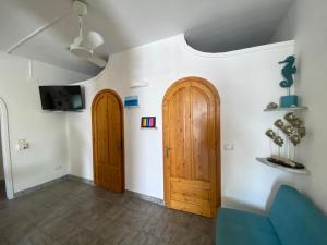 - deux portes en bois dans le salon avec un canapé dans l'établissement Villa Heraclea sul mare, à Trappeto