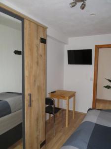 1 dormitorio con escritorio, 1 cama y 1 mesa en Kleines gemütliches Monteurzimmer en Dresden