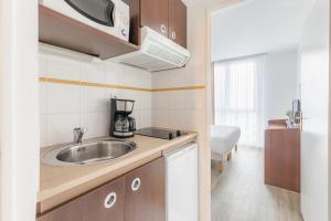 una pequeña cocina con fregadero en una habitación en Appart'City Confort Brest en Brest