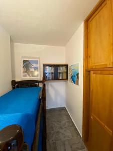 a bedroom with a blue bed and a wooden door at Villa Heraclea sul mare in Trappeto