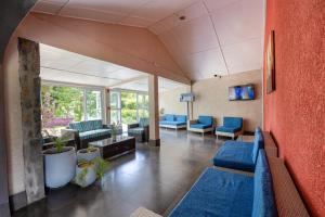 une salle d'attente dans un hôpital avec des canapés bleus dans l'établissement Le Grand Bleu Hotel, à Trou aux Biches