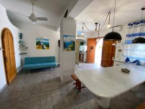 a living room with a table and a blue couch at Villa Heraclea sul mare in Trappeto