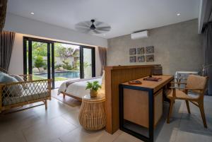 a bedroom with a bed and a desk and a table at Villa Pantai Indah - 100m to Pererenan Beach in Canggu