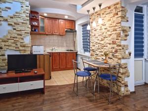 cocina con mesa, sillas y pared de piedra en Home Hotel Apartments on Livoberezhna, en Kiev