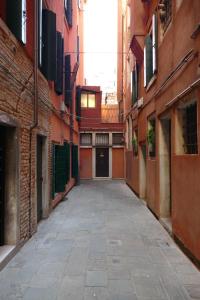 een leeg steegje tussen twee gebouwen met een deur bij Ecco Suites Apartments in Venetië