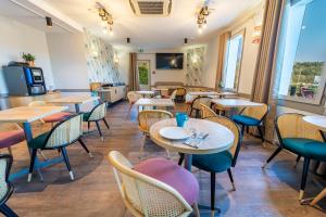 een restaurant met tafels en stoelen in een kamer bij Sure Hotel by Best Western Sarlat-la-Canéda - Ex Hôtel Altica in Sarlat-la-Canéda