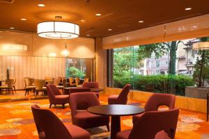 una sala d'attesa con tavoli e sedie in un edificio di Morioka Grand Hotel Annex a Morioka