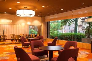 uma sala de espera com mesas e cadeiras num edifício em Morioka Grand Hotel Annex em Morioka