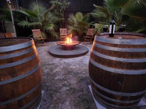 dos barriles de vino con fuego en un patio en Cool Change Accommodation And Venue Hire, en Nelson Bay